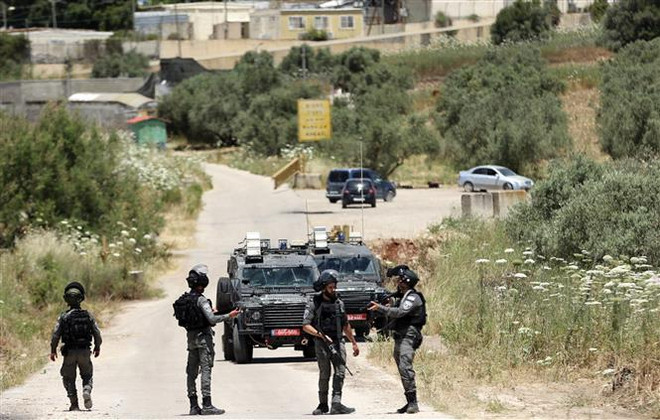 Lực lượng an ninh Israel phong tỏa tuyến đường ở khu Bờ Tây. (Ảnh: AFP/TTXVN) Tái bùng phát đụng độ tại Jerusalem và Bờ Tây, nhiều người bị thương ảnh 1
