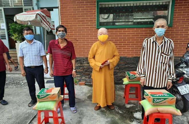 Các chư tăng quận 11, Thành phố Hồ Chí Minh tặng nhu yếu phẩm cho người dân nghèo gặp khó khăn do dịch COVID-19. (Ảnh: TTXVN phát) Đồng bào có đạo tại Thành phố Hồ Chí Minh hỗ trợ tuyến đầu chống dịch ảnh 1