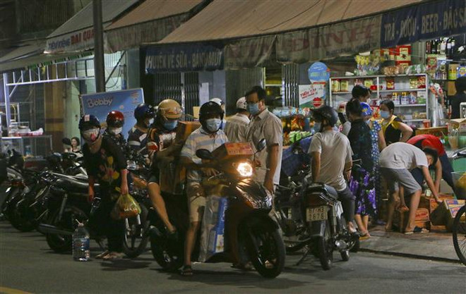 Người dân thành phố Vị Thanh, tỉnh Hậu Giang ùn ùn đi mua thực phẩm tối 17/7. (Ảnh: Duy Khương/TTXVN) Triển khai nhiều biện pháp quyết liệt để phòng, chống dịch COVID-19 ảnh 1