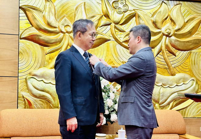 Chủ tịch Liên hiệp Các tổ chức hữu nghị Việt Nam Phan Anh Sơn đeo Kỷ niệm chương cho Đại sứ Yamada Takio. (Ảnh: Việt Đức/TTXVN) ttxvn_ky niem chuong 2.jpg