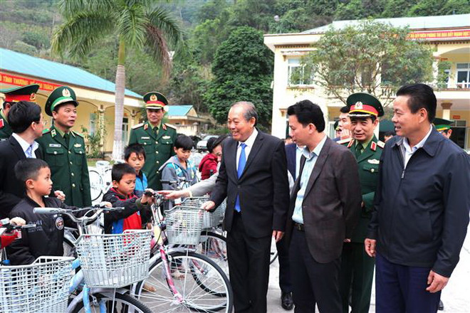 Phó Thủ tướng Thường trực Chính phủ Trương Hòa Bình tặng xe đạp cho các cháu học sinh có hoàn cảnh khó khăn trên địa bàn huyện Vị Xuyên. (Ảnh: Minh Tâm/TTXVN) Phó Thủ tướng Trương Hòa Bình thăm và tặng quà Tết tại Hà Giang ảnh 2