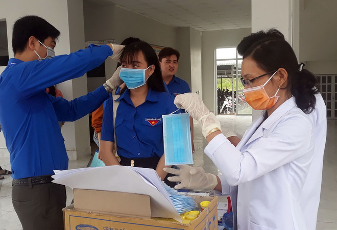 Phát khẩu trang y tế miễn phí cho sinh viên. (Ảnh: Lê Sen/TTXVN) Bộ Giáo dục đề nghị các trường cho sinh viên nghỉ hết tháng Hai ảnh 1