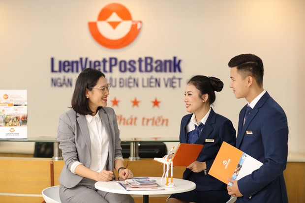 Cán bộ LienVietPostBank làm việc với khách hàng. (Ảnh: Vietnam+) HNX sắp tổ chức đấu giá 140 triệu cổ phần Ngân hàng Bưu điện Liên Việt ảnh 1