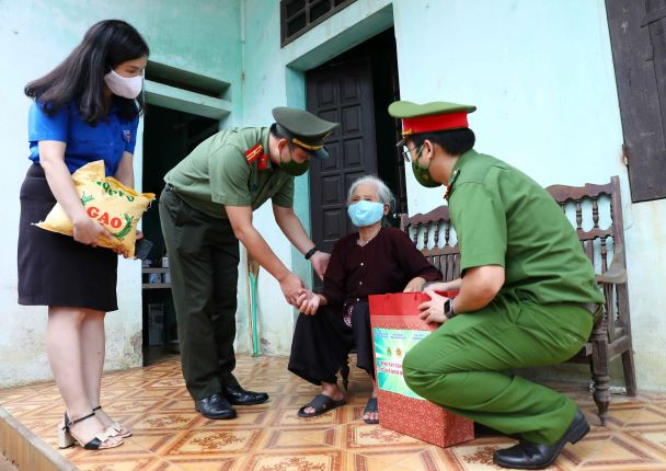 Đoàn thanh niên Công an thành phố Hà Nội thăm hỏi và động viên gia đình bà Nguyễn Thị Bé (xã Kim Nỗ, huyện Đông Anh) có hoàn cảnh khó khăn do ảnh hưởng của dịch COVID-19. (Ảnh: Phạm Kiên/TTXVN) Đoàn kết toàn dân tộc - sức mạnh để chiến thắng đại dịch COVID-19 ảnh 2
