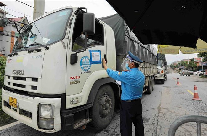Lực lượng chức năng kiểm tra giấy tờ của người và phương tiện giao thông tại chốt kiểm soát dịch bệnh COVID-19 đầu cầu Trung Hà, huyện Ba Vì, Hà Nội. (Ảnh: Vũ Sinh/TTXVN) Những chính sách hỗ trợ doanh nghiệp, người lao động nổi bật tuần qua ảnh 1