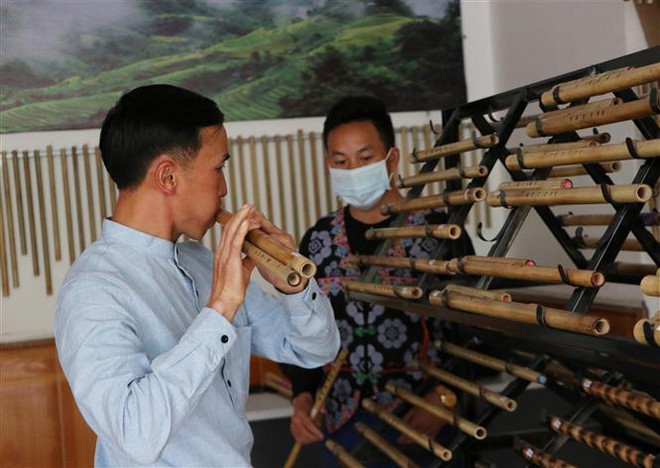 Hằng ngày, có nhiều khách hàng đến xem sản phẩm và tập thổi sáo tại cửa hàng sáo trúc của 3 thanh niên người Mông. (Ảnh: Việt Hoàng/TTXVN) Chuyện khởi nghiệp của những chàng trai đam mê 'giữ lửa' sáo Mông ảnh 2
