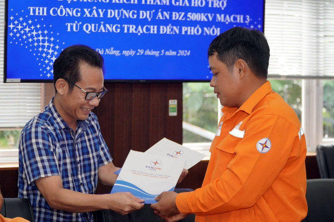 Ông Nguyễn Ngọc Ánh - Giám đốc Công ty Dịch vụ Điện lực miền Trung tặng quà động viên Đội xung kích lên đường làm nhiệm vụ vào sáng 29/5. (Ảnh: TTXVN phát) ttxvn_mach 3_2.jpg