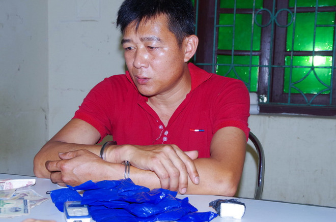 Đối tượng Lường Văn Thanh cùng tang vật tại cơ quan điều tra. (Ảnh: Xuân Tư/TTXVN) Bắt đối tượng vận chuyển trái phép 6.000 viên ma túy tổng hợp ảnh 1
