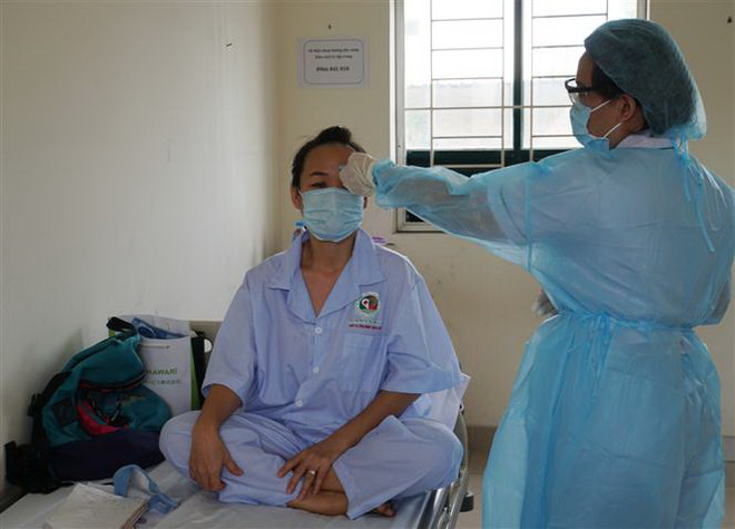 Nhân viên y tế theo dõi tình hình sức khỏe người cách ly tại khu cách ly Trung tâm quận 2. (Ảnh: Đinh Hằng/TTXVN) Lặng thầm những chuyến xe vận chuyển bệnh nhân trong đợt dịch COVID-19 ảnh 1