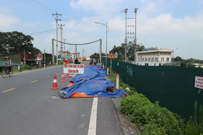 Đặt biển báo cảnh báo an toàn để phương tiện không đi qua khu vực nguy hiểm. (Ảnh: Mạnh Khánh/TTXVN) Hà Nội: Khẩn cấp kiểm tra và khắc phục sự cố nứt đê hữu Hồng ảnh 2