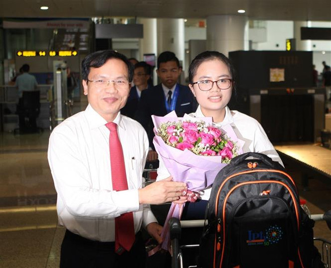 Cục trưởng Cục Quản lý chất lượng (Bộ Giáo dục và Đào tạo) Mai Văn Trinh đón, tặng hoa chúc mừng Nguyễn Khánh Linh - thành viên đoàn thi Olympic Vật lý quốc tế. (Ảnh: Thanh Tùng/TTXVN) Cô gái 'vàng' Vật lý giành học bổng từ hai trường danh tiếng của Mỹ ảnh 1