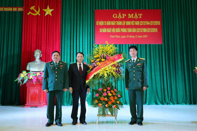 Tổng Giám đốc TTXVN Nguyễn Đức Lợi tặng hoa chúc mừng Sư đoàn 304. (Ảnh: Thành Đạt/TTXVN) Tăng cường mối quan hệ kết nghĩa giữa TTXVN và Sư đoàn 304 ảnh 1