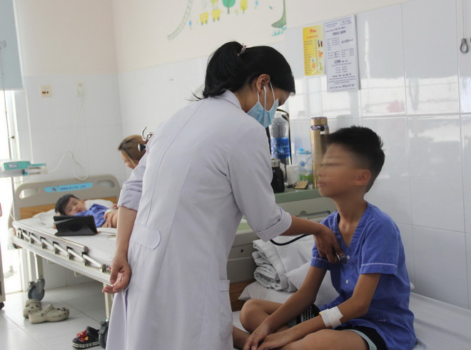 Bác sỹ Bệnh viện Đa khoa Tâm Trí Nha Trang kiểm tra sức khỏe cho bệnh nhi trong vụ ngộ độc thực phẩm, sáng 19/3. (Ảnh: Phan Sáu/TTXVN) ttxvn_com ga 2.jpg