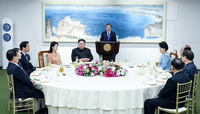 Nhà lãnh đạo Triều Tiên Kim Jong-un (thứ 5, trái) cùng phu nhân Ri Sol Ju (thứ 4, trái), Tổng thống Hàn Quốc Moon Jae-in (phía sau) cùng phu nhân Kim Jung-sook (thứ tư, phải) dự tiệc mừng tại làng đình chiến Panmunjom ngày 27/4. (Nguồn: Yonhap/TTXVN) Hàn Quốc và Triều Tiên "bóng gió" khả năng xây đường sắt cao tốc ảnh 1