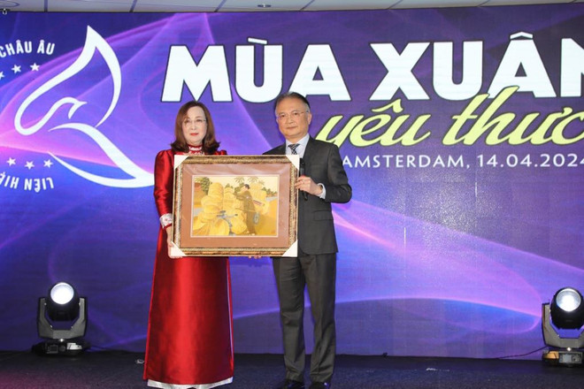 Đại sứ Việt Nam tại Hà Lan Ngô Hướng Nam trao cho Chủ tịch LHHPNVN tại châu Âu Nguyễn Việt Triều bức tranh để tham gia đấu giá hỗ trợ “Quỹ trái tim hồng” tại Việt Nam(Ảnh: TTXVN) 3333.jpg