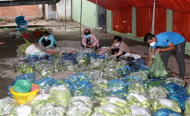 Các đoàn thể thị trấn Vàm Láng chuẩn bị rau củ quả hỗ trợ người dân trong khu vực phong tỏa. (Ảnh: Hữu Chí/TTXVN) Tiền Giang: Triển khai các phương án dập ổ dịch COVID-19 tại Vàm Láng ảnh 2