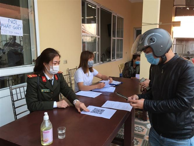 Lực lượng chức năng thành phố Hải Phòng hướng dẫn công dân khai báo y tế điện tử tại các chốt kiểm soát dịch bệnh COVID-19. (Ảnh: TTXVN phát) Hải Phòng yêu cầu xử phạt nữ giáo viên khai báo không trung thực ảnh 1