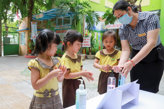 Các em được cô giáo hướng dẫn rửa tay khử khuẩn trước khi vào lớp. (Nguồn: Vietnam+) Đà Nẵng cho học sinh uống sữa học đường ngay ngày đầu tựu trường ảnh 1