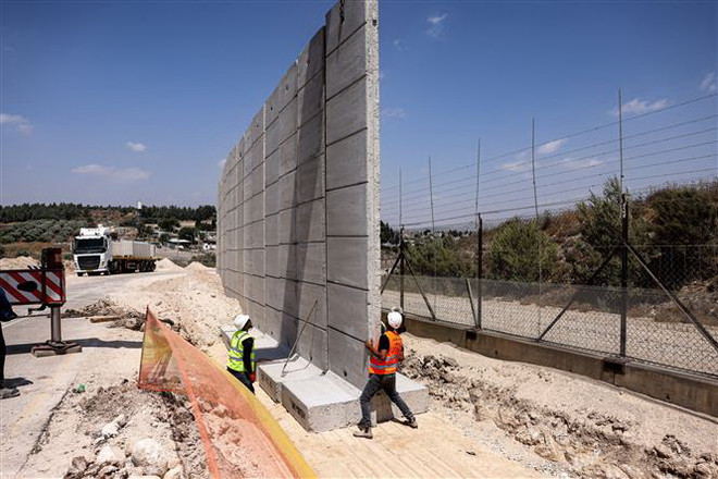 Công nhân Israel tham gia xây dựng bức tường an ninh tại phía Bắc khu Bờ Tây. (Ảnh: AFP/TTXVN) Israel nâng cấp hàng rào thép gai ngăn cách với khu Bờ Tây ảnh 1