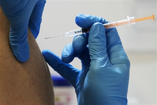 Nhân viên y tế tiêm vaccine ngừa COVID-19 cho người dân tại Tokyo, Nhật Bản. (Ảnh: AFP/TTXVN) Thế giới có thể đối mặt với tình trạng dư thừa vaccine ngừa COVID-19 ảnh 1