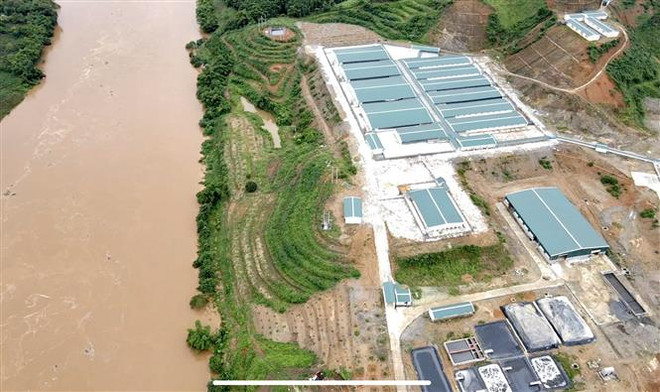 Những chiếc bể chứa chất thải chăn nuôi của trang trại lợn nằm lộ thiên ngay sát bờ sông Hồng. (Ảnh: Tuấn Anh/TTXVN) Yên Bái kiểm tra trang trại lợn gây ô nhiễm sau phản ánh của TTXVN ảnh 1