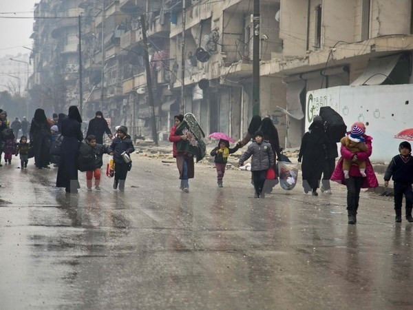 Người dân Syria sơ tán khỏi các khu vực do quân nổi dậy kiểm soát để đến các khu vực đã được quân Chính phủ giải phóng ở Aleppo ngày 13/12. (Nguồn: AFP/TTXVN) Liên hợp quốc thành lập nhóm điều tra tội ác chiến tranh ở Syria ảnh 1