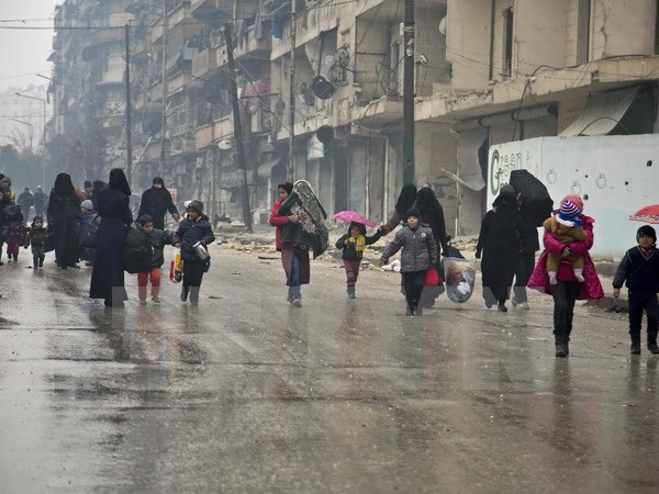 Người dân Syria sơ tán khỏi các khu vực do quân nổi dậy kiểm soát để đến các khu vực đã được quân Chính phủ giải phóng ở Aleppo ngày 13/12. (Nguồn: AFP/TTXVN) Syria: Hoàn tất 2 đợt sơ tán dân thường khỏi miền Đông Aleppo ảnh 1