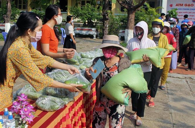 Ngoài gạo còn có các phần rau xanh hỗ trợ cho người dân gặp khó khăn. (Ảnh: Xuân Triệu/TTXVN) Học sinh làm 'ATM gạo' giúp đỡ người nghèo bớt khó khăn do COVID-19 ảnh 1