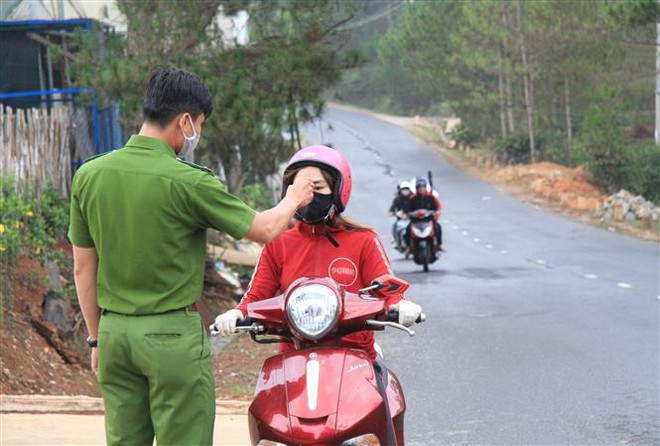 Đo thân nhiệt người điều khiển phương tiện giao thông tại chốt kiểm dịch. (Ảnh: Đặng Tuấn/TTXVN) Tạm giữ đối tượng không đeo khẩu trang, tấn công chiến sỹ công an ảnh 1