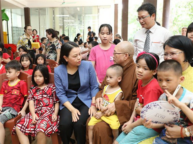 Phó Chủ tịch-Tổng Thư ký Ủy ban Trung ương Mặt trận Tổ quốc Việt Nam Nguyễn Thị Thu Hà thăm hỏi trẻ mồ côi tại chùa. (Ảnh: Minh Đức/TTXVN) Đại lễ Phật Đản: Lan tỏa văn hóa, tinh thần hòa bình của Phật giáo ảnh 2