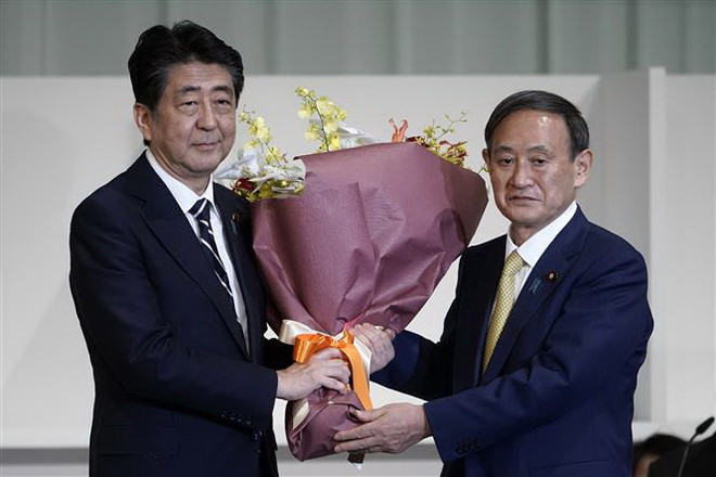 Thủ tướng Nhật Bản sắp mãn nhiệm Shinzo Abe (trái) chúc mừng tân Chủ tịch đảng Dân chủ Tự do (LDP) cầm quyền vừa đắc cử Yoshihide Suga tại Tokyo ngày 14/9/2020. (Ảnh: TTXVN phát) Tân Chủ tịch LDP cam kết kế thừa các chính sách của Thủ tướng Abe ảnh 1