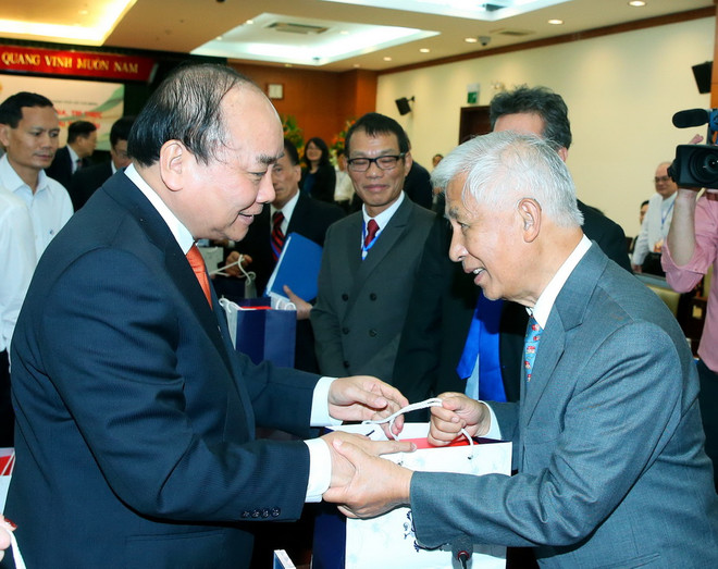 Thủ tướng Nguyễn Xuân Phúc tặng quà cho các đại biểu. (Ảnh: Thống Nhất/TTXVN) Thủ tướng Nguyễn Xuân Phúc gặp mặt trí thức Việt kiều tiêu biểu ảnh 1