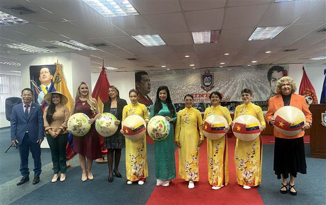 Đại sứ Việt Nam tại Venezuela Lê Viết Duyên (bìa trái) và Thứ trưởng Ngoại giao Venezuela Capaya Rodriguez (bìa phải) tại lễ khai mạc sự kiện. (Ảnh: TTXVN phát) Giới thiệu áo dài truyền thống của Việt Nam tại Venezuela ảnh 1
