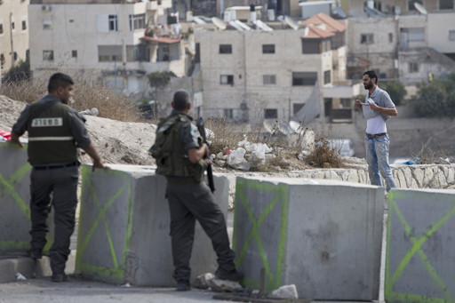 Cảnh sát Israel bắt một người Palestine vạch áo lên để kiểm tra. (Nguồn: AP) Nhà hoạt động Palestine không chấp nhận các giới hạn ông Kerry đề xuất ảnh 1