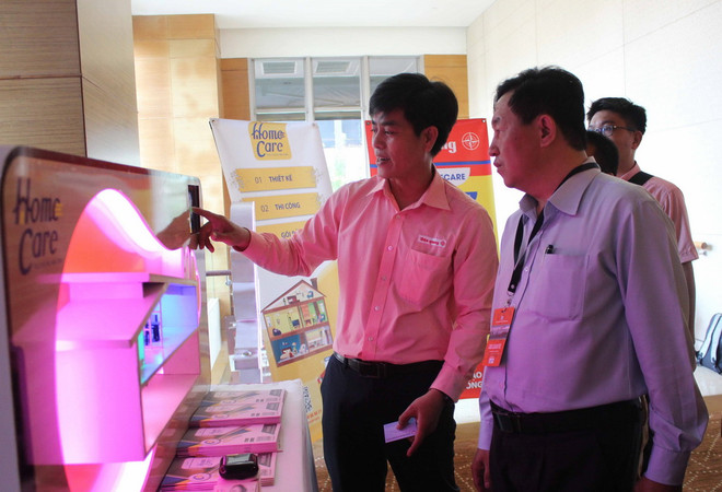 Doanh nghiệp giới thiệu sản phẩm tại khu triển lãm bên lề hội thảo. (Ảnh: Xuân Anh/TTXVN) An toàn thông tin - ưu tiên hàng đầu của Việt Nam trong phát triển IoT ảnh 1