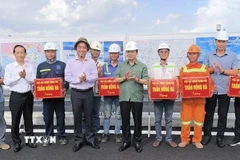 Phó Thủ tướng Trần Hồng Hà tặng quà cho công nhân thi công cầu Rạch Miễu 2. (Ảnh: Huỳnh Phúc Hậu/TTXVN)