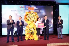 Ông Ngô Xuân Thắng, Phó Bí thư Thành ủy Đà Nẵng thay mặt lãnh đạo thành phố trao hoa chúc mừng đại diện ngành y tế và các đơn vị tổ chức. (Ảnh: Trần Lê Lâm/TTXVN)