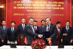 Phó Chủ tịch UBND tỉnh Long An Nguyễn Minh Lâm và Phó Tỉnh trưởng tỉnh Thanh Hải Liu Tao, ký Ý định thư. (Ảnh: Thanh Bình/TTXVN)