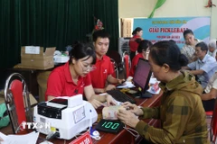 Người dân xã Gia Bình, tỉnh Bắc Ninh nhận tiền hỗ trợ chi trả bồi thường giải phóng mặt bằng. (Ảnh: Thanh Thương/TTXVN)