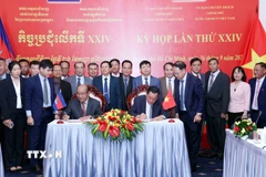 Thượng tướng Võ Minh Lương (phải), Thứ trưởng Bộ Quốc phòng, Chủ tịch Ủy ban Chuyên trách Chính phủ nước CHXHCN Việt Nam và Đại tướng Pol Saroeun (trái), Cố vấn cấp cao của Quốc vương Campuchia, Chủ tịch Ủy ban Chuyên trách Chính phủ Campuchia ký biên bản Kỳ họp. (Ảnh: Xuân Khu/TTXVN)