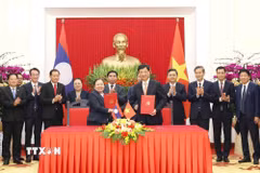 Trưởng Ban Tổ chức Trung ương Nguyễn Duy Ngọc và Trưởng Ban Tổ chức Trung ương Đảng Nhân dân Cách mạng Lào Sisay Leudetmounsone trao Thỏa thuận hợp tác giữa hai cơ quan. (Ảnh: Phương Hoa/TTXVN)