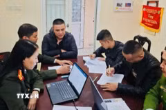 Cán bộ công an lấy lời khai các đối tượng xuất nhập cảnh trái phép sang Campuchia làm việc trong các sòng bạc trực tuyến lừa đảo trái phép. (Ảnh TTXVN phát)