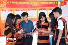 Đồng bào Xơ Đăng (xã Trà Linh, thành phố Đà Nẵng) theo dõi trên điện thoại các video clip, Inforgraphics hướng dẫn cách thức đi bỏ phiếu. (Ảnh: Trần Tĩnh/TTXVN)