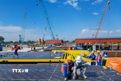 Công trường thi công dự án cầu Tứ Liên trên sông Hồng đang được triển khai với nhiều hạng mục nền móng, tập kết máy móc và vật liệu phục vụ thi công. Ảnh: Lê Đông - TTXVN