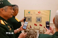 Các cựu chiến binh quét mã QR để xem triển lãm 3D trực tuyến “Hỡi đồng bào Thủ đô”. (Ảnh: Thanh Tùng/TTXVN)
