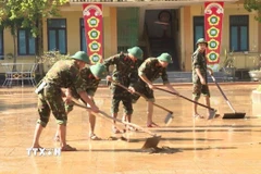 Cán bộ, chiến sỹ lực lượng vũ trang tỉnh Quảng Trị không quản ngại khó khăn, tích cực hỗ trợ địa phương khắc phục hậu quả mưa lũ. (Ảnh: Võ Dung/TTXVN)