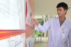 Sinh viên trường Đại học Y Dược, Đại học Huế, xem danh sách đại biểu ứng cử tại điểm bầu cử tại trường. (Ảnh: Văn Dũng/TTXVN)