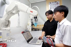 Sinh viên thực hành thử nghiệm các thuật toán điều khiển cánh tay robot tại phòng thí nghiệm Robotics, Trường Đại học Công nghiệp Thành phố Hồ Chí Minh. (Ảnh: Thanh Vũ/TTXVN)
