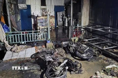 Dây điện cháy rồi bị đứt rơi xuống nhà dân gây cháy. (Ảnh: TTXVN phát)