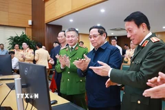 Thủ tướng Phạm Minh Chính thực hiện thao tác nhắn tin chúc Tết người tham gia giao thông qua ứng dụng giao thông. (Ảnh: Dương Giang/TTXVN)